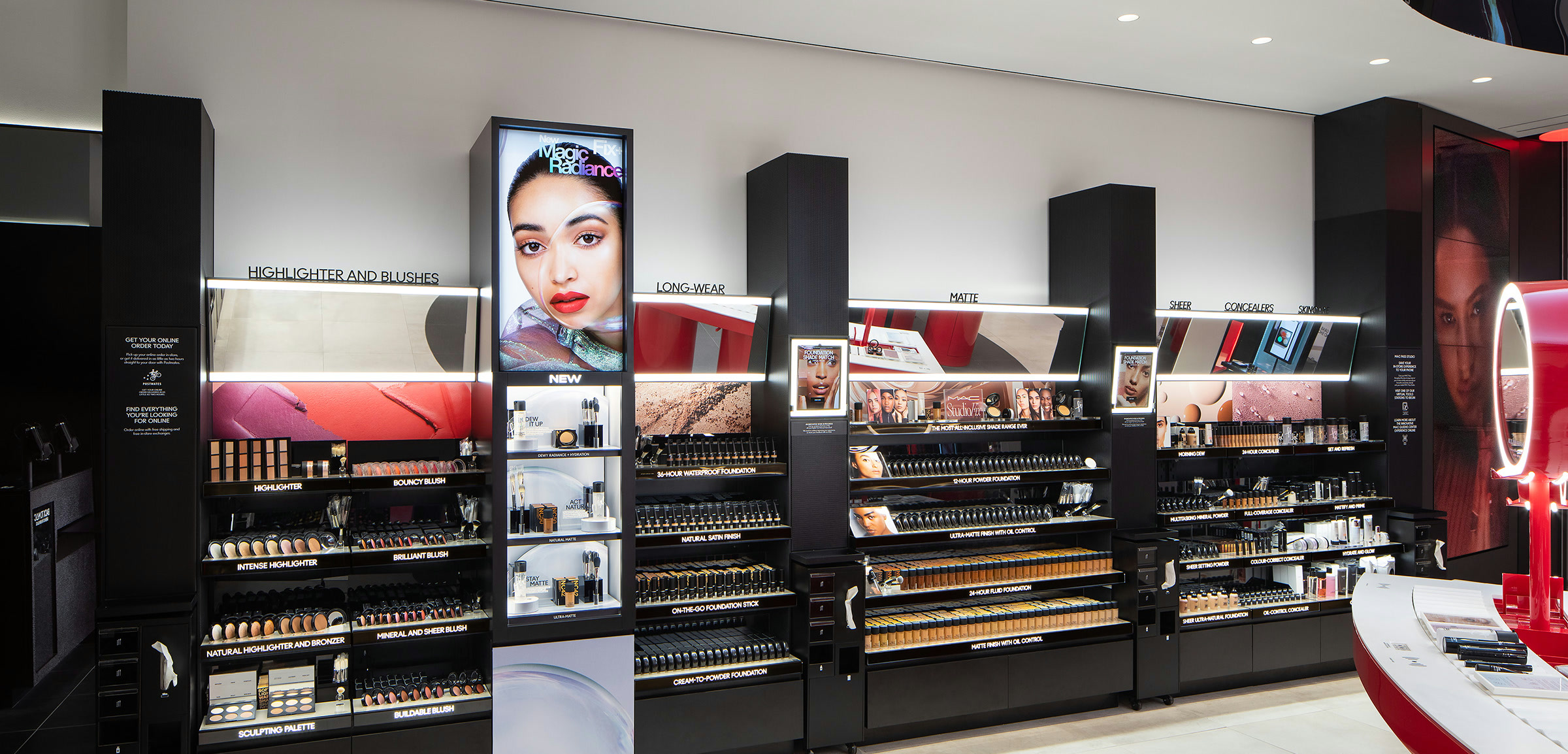 Wide view of the MAC concept store with red circular digital stations and product walls